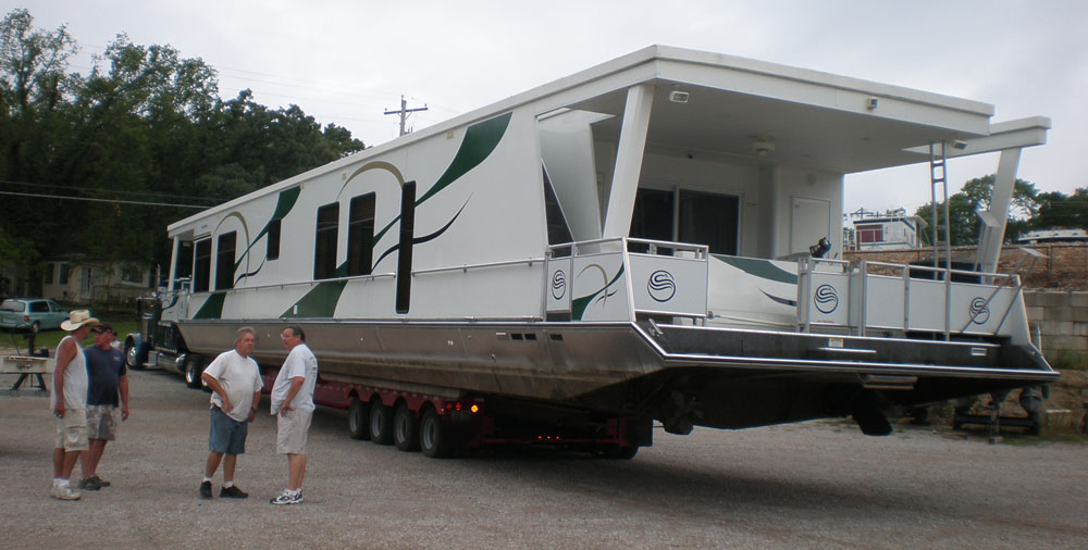 Preparations | 4 men preparing to haul a large boat on a semi truck